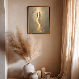May include: A rectangular framed wall art piece featuring an abstract painting of two glowing, ethereal figures in shades of gold, beige, and soft brown. The artwork is displayed in a thin gold frame, showcasing a vertical composition of light.