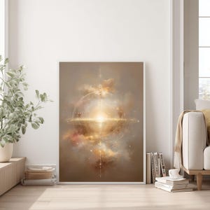 May include: Framed abstract art print featuring a celestial design with a bright central light source. The artwork showcases a blend of gold, beige, and white hues, with a circular and linear composition. The print is displayed in a bright, airy room.
