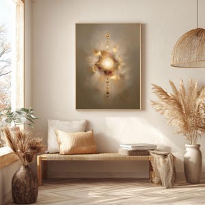 May include: Abstract art print in a gold frame. The artwork features a central, radiant light source surrounded by soft, cloud-like forms in shades of beige, gold, and brown. A vertical line of small, golden circles and dots extends downward from the light source.