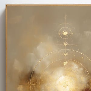 May include: Abstract art piece in a wooden frame. The artwork features a muted color palette of beige, brown, and gold. Gold circular and linear elements are layered over the background, creating a celestial or geometric design.