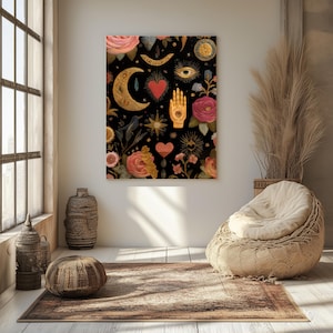 Peut inclure: Une impression d'art encadr&eacute;e sur toile avec un fond noir orn&eacute; de motifs floraux et c&eacute;lestes dor&eacute;s et roses. Le motif comprend un croissant de lune, une main, des c&oelig;urs, des &eacute;toiles et des fleurs. L'&oelig;uvre est expos&eacute;e dans une pi&egrave;ce lumineuse avec un tapis et une chaise.