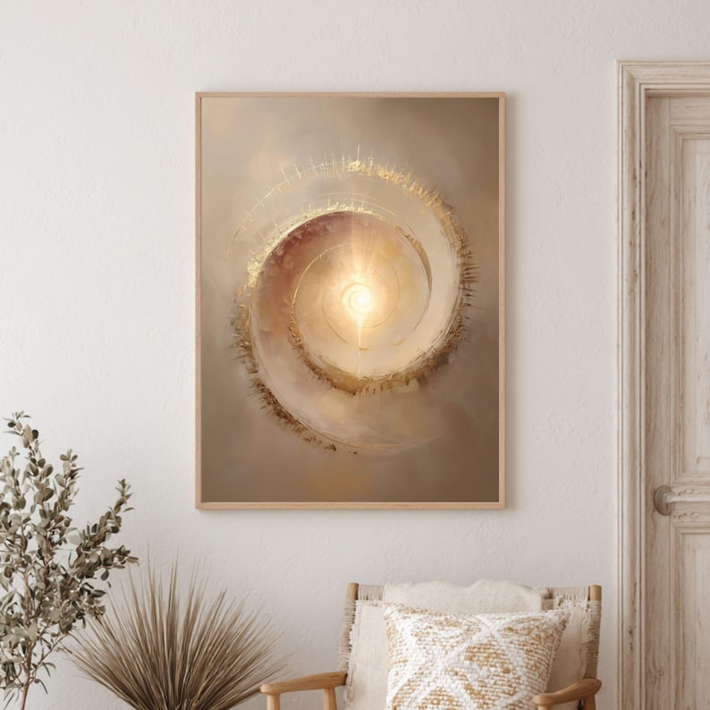 May include: Abstract art print featuring a spiral design with a bright, golden center. The artwork is framed in a light wood frame and hangs on a neutral-toned wall. The spiral artwork has a warm color palette with gold and beige tones.