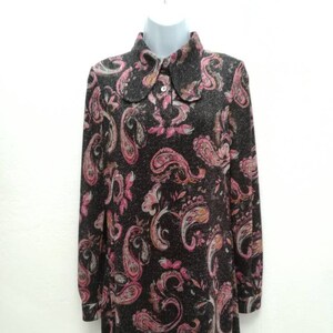 May include: A long-sleeved dress with a paisley print in shades of pink, brown, and white. The dress has a collared neckline and a button closure.