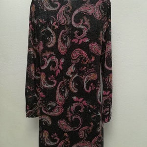 May include: A long-sleeved black shirt with a paisley pattern in shades of pink, orange, and white. The shirt has a collared neckline and a button-up front.