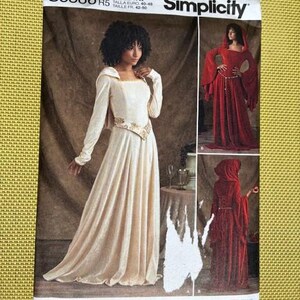 May include: Simplicity sewing pattern S8866 R5 featuring a cream-colored medieval gown with long sleeves and a decorative belt. The pattern also shows a red hooded gown. Size US 14-22.