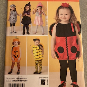 May include: Simplicity sewing pattern 2304 featuring children's Halloween costumes. The costumes include a ladybug, witch, pumpkin, and bumblebee. The pattern includes sizes A 1/2, 1, 2, 3, and 4. The Simplicity logo is at the top right.