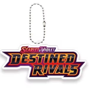 Pu&ograve; includere: Un portachiavi bianco con la scritta "SCARLET & VIOLET DESTINED RIVALS" in rosso, arancione e viola. &Egrave; attaccato a una catena a sfera argentata.
