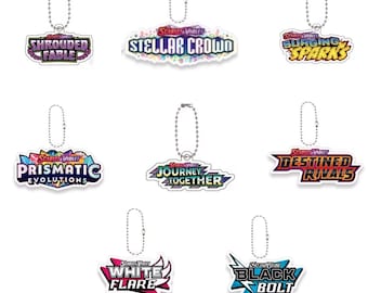 Pokémon Nyckelring | TCG Set Logotyp (Stellar Crown, Surging Sparks, Prismatic Evolutions, Destined Rivals) – Pärm och Samlartillbehör