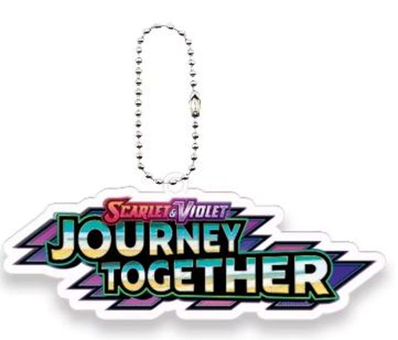 Pu&ograve; includere: Un portachiavi con il logo "Scarlet & Violet Journey Together". Il logo &egrave; un design colorato con testo in pi&ugrave; colori, tra cui rosso, blu, verde e giallo. Il portachiavi ha una catena di perline argentata.