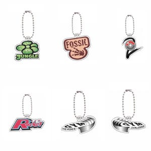 May include: Six acrylic keychains with metal ball chains, featuring logos for Jungle, Fossil, a red and white ball icon, Team Rocket, Gym Heroes, and Gym Challenge. Each charm displays distinct graphic designs and text labels in various colors.