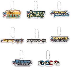May include: A selection of colourful, die-cut keychains displaying logos and text. The keychains feature the phrases "Roaring Skies," "Ancient Origins," "Break Through," "Break Point," "Generations," "Fates Collide," "Steam Siege," and "Evolutions."