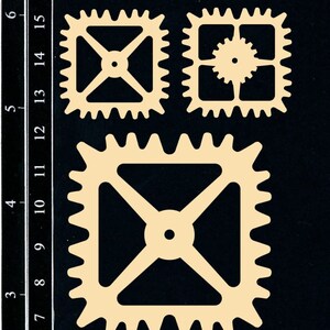 May include: Beige-colored, square-shaped gears in various sizes, arranged on a black background. The gears have intricate designs, with toothed edges and internal cutouts. The image includes a ruler with inch and cm measurements.