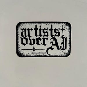 以下が含まれることがあります： 長方形のステッカー。角が丸く、ゴシック体の「artists over Aj」の文字が描かれています。ステッカーは白黒で、点線で縁取られ、Instagramのハンドルネーム@crimsonhoneyinkも表示されています。