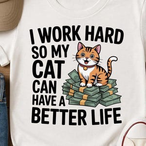 May include: White t-shirt featuring the text "I WORK HARD SO MY CAT CAN HAVE A BETTER LIFE" and a cartoon cat on money. The cat is orange and brown. The shirt is shown with blue jeans, a beige cap, and white trainers.