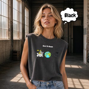 May include: Black sleeveless crop top with the text "Born To Roam" and a graphic of a car, globe, and airplane. The globe is blue and green. The top is worn by a person.