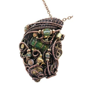 May include: A steampunk-style pendant necklace with a copper-colored wire-wrapped design. The pendant features green and gold accents, including beads and a cylindrical green stone. The intricate design incorporates small gears and other mechanical elements.