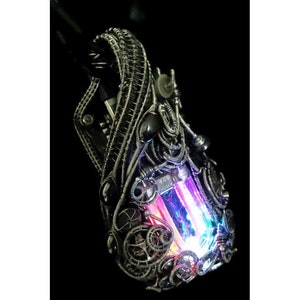 May include: A silver steampunk-style pendant with a clear crystal that is lit up with pink, blue, and purple light.