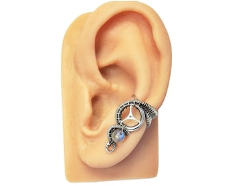 May include: Silver ear cuff with a gear design and a moonstone bead.