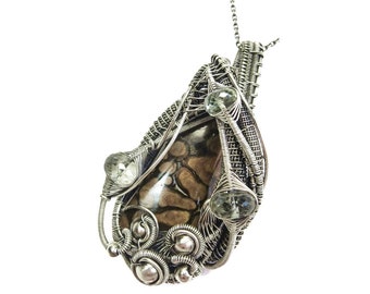 May include: A silver wire wrapped pendant featuring a brown and white patterned stone with three clear faceted stones.