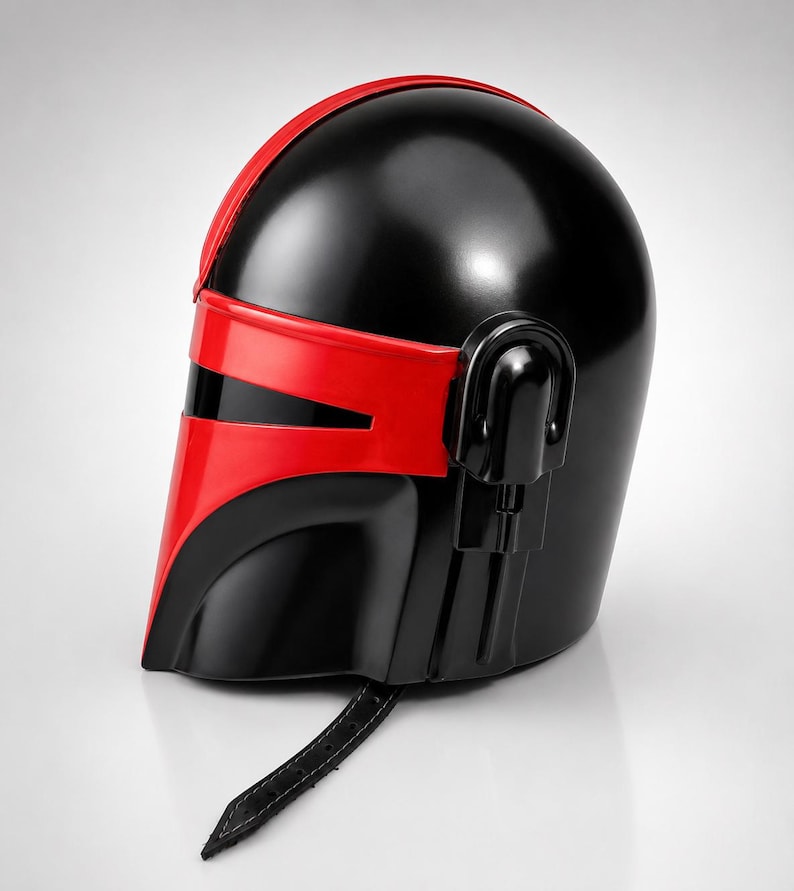 May include: A glossy black and red helmet featuring a T-shaped visor opening, a smooth rounded dome, and a side-mounted ear piece. A black leather-like chin strap with visible stitching hangs from the bottom edge of the helmet structure.