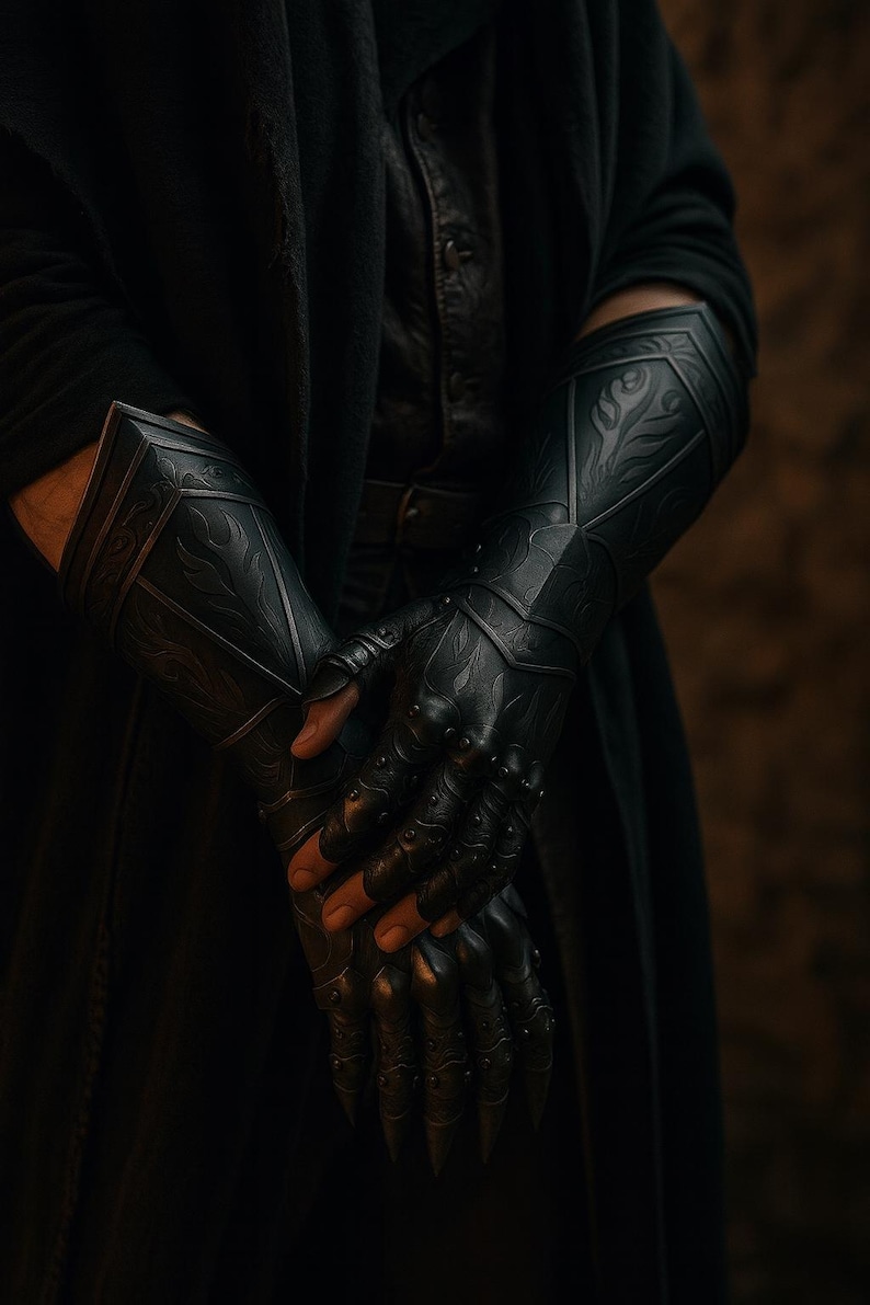 May include: A pair of black forearm gauntlets and fingerless gloves featuring intricate embossed flame-like patterns and small metallic studs along the knuckles and fingers. The armor pieces cover the forearms and hands with a dark finish.