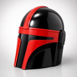 May include: A glossy black and red helmet featuring a smooth, rounded dome, a central vertical red stripe, and a horizontal red band across the visor area. The design includes a T-shaped faceplate with red accents and a side ear piece detail.