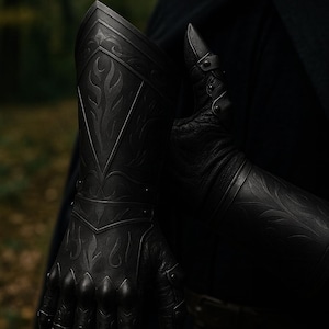 May include: A black gauntlet featuring intricate embossed flame-like patterns on the forearm plate and articulated finger segments. The armor piece is constructed with a textured leather base and rigid plates, showcasing detailed metalwork and rivets.