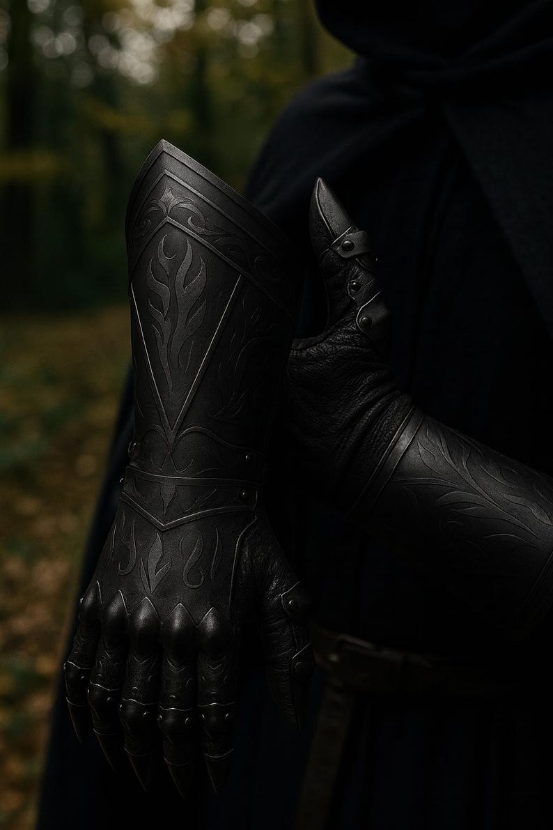 May include: A black gauntlet featuring intricate embossed flame-like patterns on the forearm plate and articulated finger segments. The armor piece is constructed with a textured leather base and rigid plates, showcasing detailed metalwork and rivets.