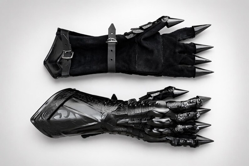 May include: A pair of black gauntlets featuring a combination of soft suede-like material and rigid, polished black metal plating. The design includes articulated finger sections topped with sharp, conical spikes and adjustable leather buckle straps.