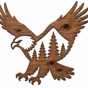 May include: Wooden wall art featuring an eagle in flight, with a mountain and pine tree silhouette. The eagle is carved from dark brown wood, showcasing the natural grain. The design is a nature-themed decorative piece.