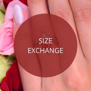 May include: A close-up of a hand wearing a ring with red and clear stones. The ring is set against a background of pink and red flowers. A red circle with the words "SIZE EXCHANGE" is superimposed over the image.
