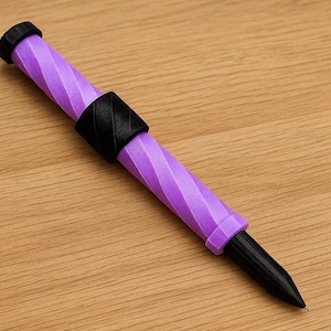 May include: A purple and black pen with a spiral design. The pen has a black tip and a black band around the middle. The pen is lying on a wooden surface.