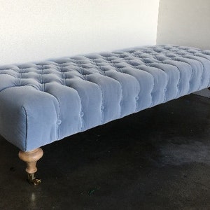 Tufted Ottoman W/ Turned Wood Feet on Casters COM image 1