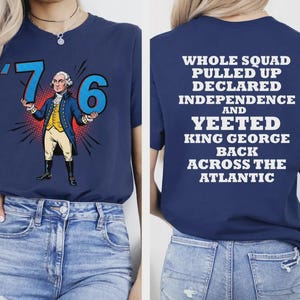 May include: Navy blue t-shirt featuring a cartoon illustration of George Washington holding the numbers '76'. The back of the shirt displays the text: 'WHOLE SQUAD PULLED UP DECLARED INDEPENDENCE AND YEETED KING GEORGE BACK ACROSS THE ATLANTIC'.
