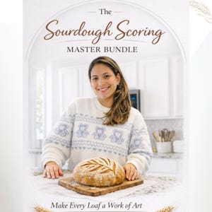May include: A woman smiles, holding a loaf of sourdough bread on a wooden board. The bread has a leaf design carved into the top. Text reads "The Sourdough Scoring Master Bundle" and "Make Every Loaf a Work of Art."