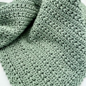 May include: A soft, sage green crocheted blanket with a textured stitch pattern.