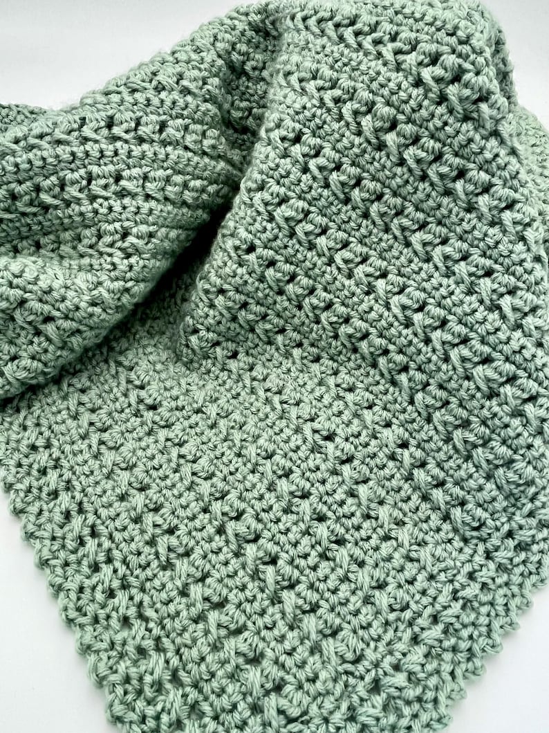 May include: A soft, sage green crocheted blanket with a textured stitch pattern.