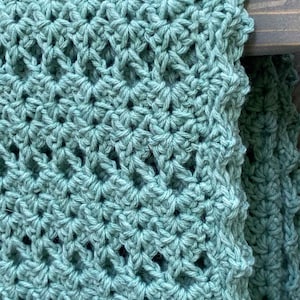 May include: A teal crocheted blanket with a diamond stitch pattern.