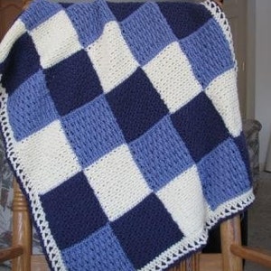 May include: A crocheted baby blanket with a checkered pattern in shades of blue and white. The blanket has a white crocheted border.