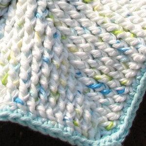 May include: White crocheted baby blanket with a blue border. The blanket has a textured, woven design with blue and green accents.