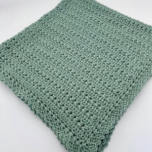 May include: A soft, sage green crocheted blanket with a textured stitch pattern.