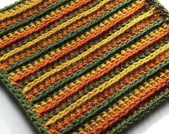 Puede incluir: Un cuadrado tejido a crochet con rayas de hilo verde, naranja y amarillo.