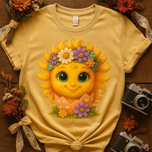 Cute cartoon sun character with big teal eyes and golden wavy rays, wearing a colorful daisy and flower crown, smiling from inside a cracked pastel pink egg covered in little hearts, with bright flowers and green grass at the base and a soft blue glowing sky behind. Playful spring and Easter graphic art, perfect for a cheerful kids T shirt design.