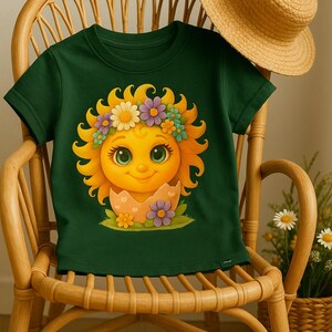 Cute cartoon sun character with big teal eyes and golden wavy rays, wearing a colorful daisy and flower crown, smiling from inside a cracked pastel pink egg covered in little hearts, with bright flowers and green grass at the base and a soft blue glowing sky behind. Playful spring and Easter graphic art, perfect for a cheerful kids T shirt design.