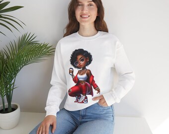 May include: White sweatshirt featuring a cartoon illustration of a stylish Black woman in red pants, a red jacket, and sneakers, holding a coffee cup. The woman is wearing glasses and a necklace. The sweatshirt has long sleeves.