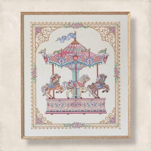 Puede incluir: Obra de arte en punto de cruz enmarcada con una escena de carrusel. El carrusel tiene tres caballos, un dosel rosa y azul y detalles florales. La obra está enmarcada en un marco de madera dorada.