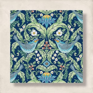 May include: A square cross-stitch pattern with a symmetrical design of blue birds, white flowers, and green foliage on a dark blue background. The artwork has a vintage, handcrafted aesthetic.