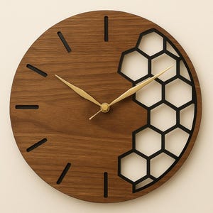 以下が含まれることがあります： 茶色の仕上げと右側の黒いハニカムデザインが施された丸い木製の壁掛け時計。 時計には金色の針と時間の黒いマーカーが付いています。 時計の直径は約30cmです。