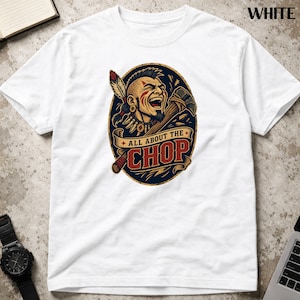 May include: White t-shirt featuring a colorful graphic of a Native American man with an axe, and the text "ALL ABOUT THE CHOP" in red and gold. The design is set within a dark blue oval.