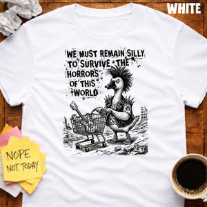 May include: White t-shirt with a punk goose graphic pushing a shopping trolley containing a guitar. The text on the shirt reads "WE MUST REMAIN SILLY TO SURVIVE THE HORRORS OF THIS WORLD." A sticky note says "NOPE NOT TODAY."
